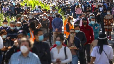 Люди в масках выстраиваются в очередь, ожидая вакцинации в Центре вакцинации Сиднейского олимпийского парка в Хоумбуше в Сиднее, Австралия, 16 августа 2021 г.