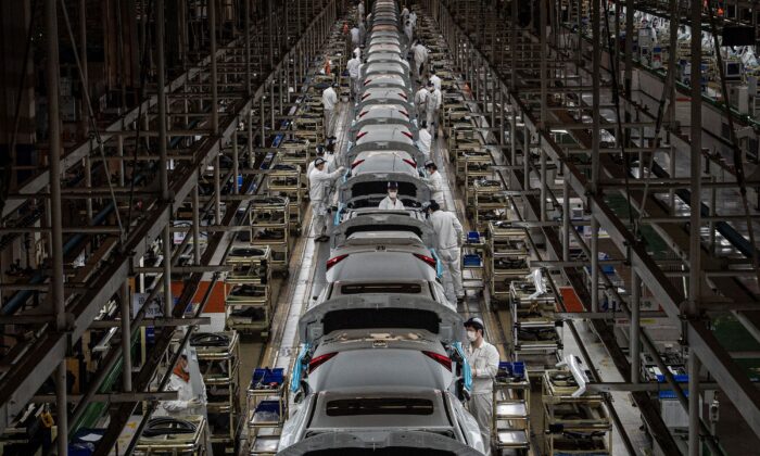 Сотрудники работают на сборочной линии автомобильного завода Dongfeng Honda в Ухане, центральная китайская провинция Хубэй, 23 марта 2020 г.