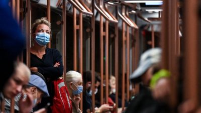 Женщина в маске на фоне продолжающейся пандемии Covid-19 стоит в метро в Москве 11 августа 2021 г.