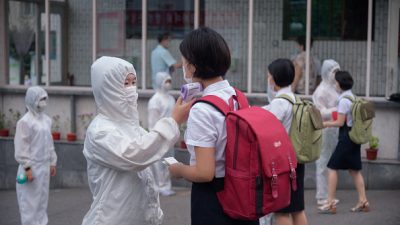 Студентам Пхеньянского университета торговли измеряют температуру перед входом в кампус в Пхеньяне 11 августа 2021 г. Photo de KIM Won Jin / AFP via Getty Images.
