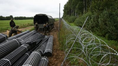 Польские солдаты разгружают материалы для строительства забора из колючей проволоки на границе с Беларусью в Зубжице-Вельке недалеко от Белостока, восточная Польша, 26 августа 2021 года. (JAAP ARRIENS/AFP via Getty Images)
