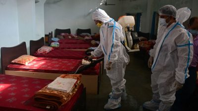 Сотрудники проводят дезинфекцию общежития во время пандемии коронавируса Covid-19 в Силигури 4 сентября 2021 г.
