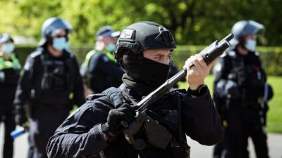 Офицер полиции по охране общественного порядка смотрит на протестующих возле Храма памяти в Мельбурне, Австралия, 22 сентября 2021 года. Darrian Traynor/Getty Images