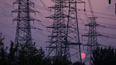 Солнце садится за опоры линий электропередач в Пекине 28 сентября 2021 г. Leo Ramirez/AFP via Getty Images
