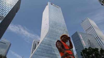Рабочий идёт перед штаб-квартирой Evergrande в Шэньчжэне, на юго-востоке Китая, 26 сентября 2021 г. Noel Celis/AFP via Getty Images
