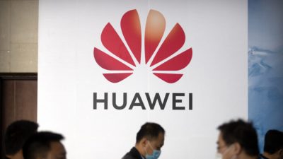 Люди проходят мимо рекламного щита китайской технологической компании Huawei на выставке PT Expo в Пекине 14 октября 2020 г. AP Photo / Mark Schiefelbein