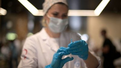 Медицинский работник готовит дозу российской вакцины «Спутник Лайт» от Covid-19 в пункте вакцинации для иностранцев на стадионе «Лужники» в Москве 14 июля 2021 года. NATALIA KOLESNIKOVA/AFP via Getty Images