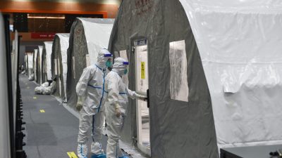 Сотрудники проверяют прибор во временной лаборатории «Огненный глаз», используемой для испытаний COVID-19, в выставочном центре в Нанкине в восточной китайской провинции Цзянсу 28 июля 2021 года. (STR/AFP via Getty Images)
