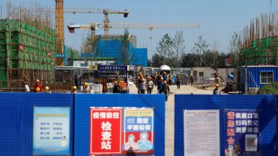 Рабочие заходят на строительную площадку одного из объектов Evergrande Group в Пекине. 22 сентября 2021 года. (Carlos Garcia Rawlins/Reuters)
