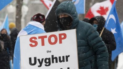 Протестующие собираются у здания парламента в Оттаве 22 февраля 2021 года, когда депутаты проголосовали за предложение, призывающее Канаду признать действия Китая против этнических мусульман-уйгуров геноцидом. The Canadian Press/Adrian Wyld