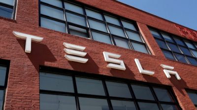 Логотип Tesla возле автосалона в Бруклинском районе Нью-Йорка 26 апреля 2021 г. (Shannon Stapleton/Reuters)
