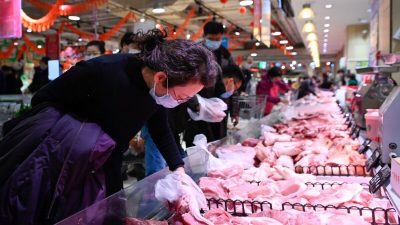Женщина выбирает свинину в супермаркете, Пекин, 10 февраля 2021 г. (WANG ZHAO/AFP via Getty Images) 