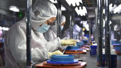Рабочие производят клейкую ленту для гибких печатных плат на заводе в Яньчэне, провинция Цзянсу, Китай, 15 сентября 2021 года. (STR/AFP via Getty Images)

