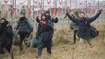 Группа мигрантов идёт вдоль белорусско-польской границы к лагерю, Гродненская область 12 ноября 2021 года. (Photo by LEONID SHCHEGLOV/BELTA/AFP via Getty Images)