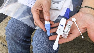Человек держит набор для тестирования на ВИЧ в Чарльстоне, 9 марта 2021 года. (AP Photo/John Raby)