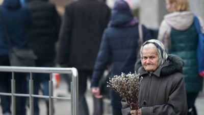 Пожилая женщина продает веточки вербы. Фото: SERGEI SUPINSKY/AFP via Getty Images)