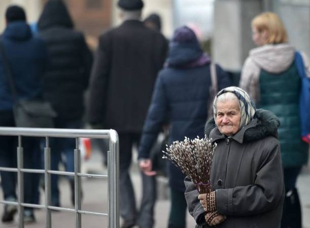 Пожилая женщина продает веточки вербы. Фото: SERGEI SUPINSKY/AFP via Getty Images)