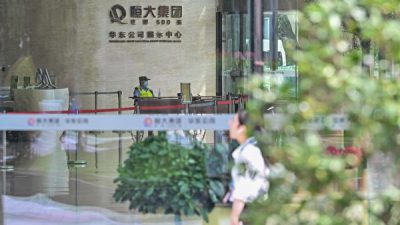Офицер полиции в вестибюле здания Evergrande Center в Шанхае 24 сентября 2021 г. (Hector Retamal/AFP via Getty Images)