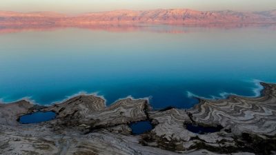 Недалеко от израильского Эйн-Геди видны воронки, заполненные водой, которые образовались в результате падения уровня воды в Мёртвом море, 21 сентября 2021 г. (Menahem KAHANA/AFP via Getty Images) 