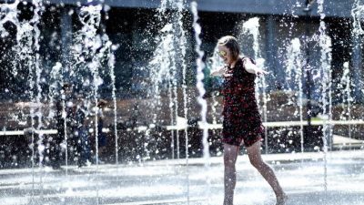 A young woman cools herself while walking across fountains in central Moscow, on May 21, 2014. The temperatures in the Russian capital reached today 28 C (82 F). AFP PHOTO / KIRILL KUDRYAVTSEV        (Photo credit should read KIRILL KUDRYAVTSEV/AFP/Getty Images)