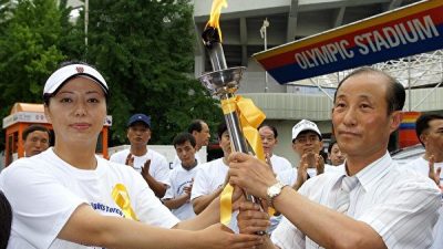 Чунг Ку-Чен (справа), заместитель главы CIPFG Korea и постоянный представитель Панкорейской коалиции за судебную реформу, принимает факел в защиту прав человека от Хуан Сяоминь (слева), представительницы Азии, на Олимпийском стадионе в Сеуле, Корея, 2 июля 2007 года (Kim Guk-hwan/The Epoch Times)