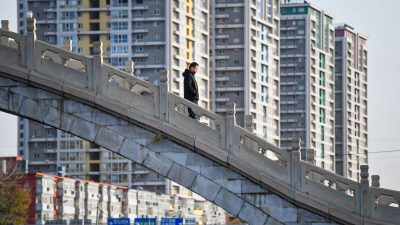 Мужчина переходит мост возле жилого комплекса в Пекине 1 декабря 2020 года. (Greg Baker/AFP via Getty Images) 