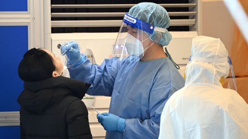 Медицинский персонал берёт мазок из носа у посетителя в рамках теста на коронавирус в центре тестирования вирусов в Сеуле 14 декабря 2021 г. Фото: Jung Yeon-Je/AFP via Getty Images
