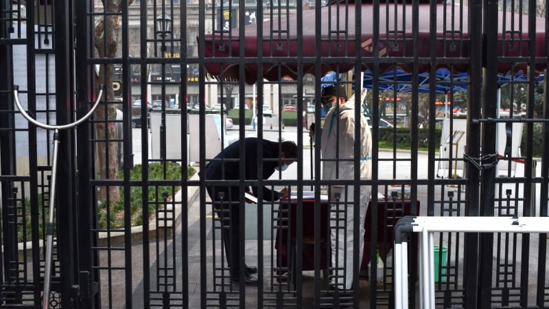 Охранник проверяет информацию о мужчине перед входом в жилой район, который находится на карантине после вспышки COVID-19 в Сиане, 23 декабря 2021 года. Фото: STR/AFP via Getty Images
