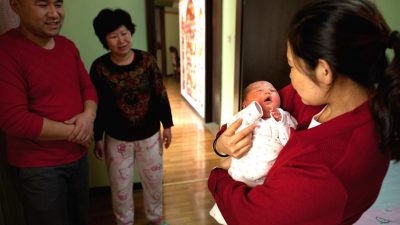 Женщина держит новорождённую девочку в родильном доме Антай в Пекине, 26 января 2012 года. (Ed Jones/AFP/Getty Images)