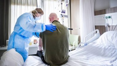 Лечащий врач слушает дыхание пациента, который выздоравливает после COVID-19. Фото:  REMKO DE WAAL/ANP/AFP via Getty Images)