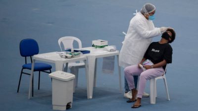 Пациенту берут мазок на COVID-19, Фото: MAURO PIMENTEL/AFP via Getty Images)