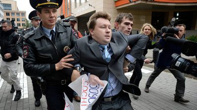 Сотрудники милиции задерживают активиста за права геев во время несанкционированной акции протеста. Фото: ALEXANDER NEMENOV/AFP via Getty Images)