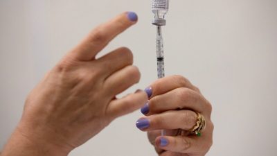 Медсестра наполняет шприцы для вакцинации от COVID-19 в клинике Pfizer-BioNTech в Саутфилде, штат Мичиган, 29 сентября 2021 года. (Emily Elconin/Reuters)