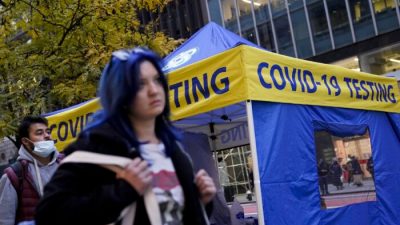 Пешеходы у палатки для тестирования COVID-19 в Нью-Йорке 2 декабря 2021 г. (John Minchillo/AP Photo)