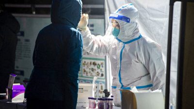 Медицинский работник берёт мазок у жителя для анализа на коронавирус COVID-19 в городе Сиань, провинция Шэньси, Китай, 25 декабря 2021 года. (STR/AFP via Getty Images)