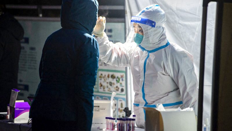 Медицинский работник берёт мазок у жителя для анализа на коронавирус COVID-19 в городе Сиань, провинция Шэньси, Китай, 25 декабря 2021 года. (STR/AFP via Getty Images)