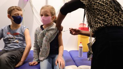 Дети получают дозу вакцины COVID-19 Pfizer-BioNTech Comirnaty в детском отделении центра вакцинации Lanxess Arena в Кёльне, Германия, 18 декабря 2021 года. (Andreas Rentz/Getty Images) 