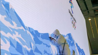 Рабочий ремонтирует видеостену в Главном медиацентре перед церемонией открытия зимних Олимпийских игр в феврале 9 января 2022 года в Пекине. (Katopodis/Getty Images