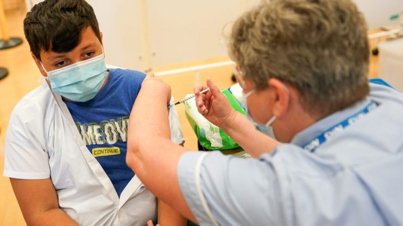 13-летний Феликс Дима из Ньюкасла получает вакцину COVID-19 от компании Pfizer-BioNTech в академии Excelsior в Ньюкасле-на-Тайне, Англия, 22 сентября 2021 года. (Ian Forsyth/Getty Images)