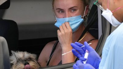 У женщины берут мазок в клинике по сдаче анализов на COVID-19 на пляже Бонди в Сиднее, 21 декабря 2021 года. (Rick Rycroft/AP Photo)
