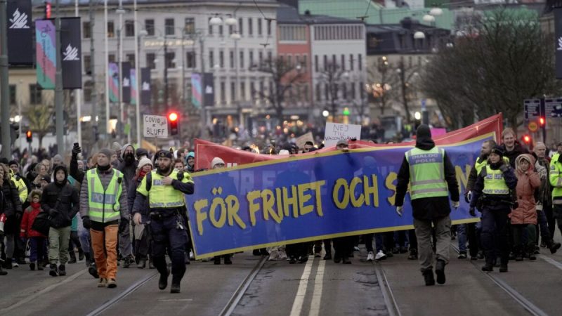 Протестующие маршируют во время демонстрации против ограничений из-за COVID-19 в Гётеборге, Швеция, 22 января 2022 года. (Bjorn Larsson Rosvall/TT News Agency via AP)