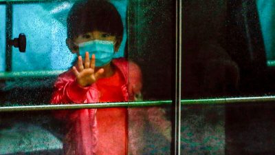 Ребёнок с жителями, эвакуированными из государственного жилого дома после вспышки нового коронавируса возле дома Хонг Мэй, в поместье Чунг Хонг в Гонконге, 11 февраля 2020 года. Фото: Tyrone Siu/Reuters
