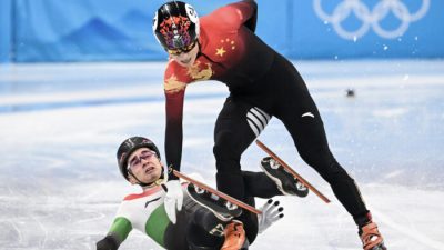 Hungary's Shaolin Sandor Liu (L) falls next to China's Ren Ziwei after crossing the finish line in the final A of the men's 1000m short track speed skating event during the Beijing 2022 Winter Olympic Games at the Capital Indoor Stadium in Beijing on February 7, 2022. (Photo by Anne-Christine POUJOULAT / AFP) (Photo by ANNE-CHRISTINE POUJOULAT/AFP via Getty Images)