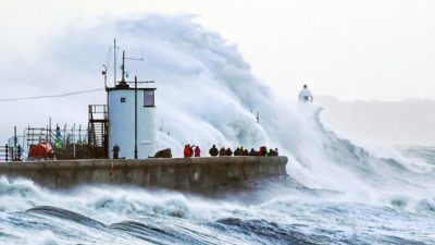 Волны разбиваются о морскую стену и маяк Порткол в Портколе, Бридженд, Уэльс, во время шторма «Юнис» на южном побережье Великобритании, 18 февраля 2022 года. (PA)