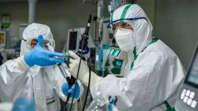 Врач лечит пациента, зараженного вирусом КПК, в больнице в Ухане, провинция Хубэй, Китай, 24 февраля 2020 года. (STR/AFP via Getty Images)