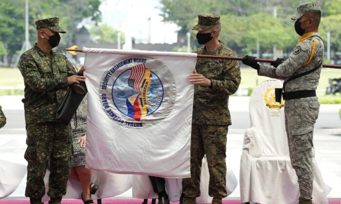 Руководитель учений на Филиппинах, генерал-майор Чарлтон Шон Гаерлан из ВМС Филиппин (слева) и руководитель учений в США, генерал-майор Джей Баргерон (справа) из Корпуса морской пехоты США разворачивают флаг Balikatan во время церемонии открытия военных учений CampAguinaldo, Кесон-Сити, Филиппины, 28 марта 2022 года. (AaronFavila/AP Photo)
