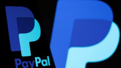 Логотип PayPal на смартфоне перед таким же логотипом, изображённым на этой иллюстрации, сделанной 8 сентября 2021 года. (Dado Ruvic/Illustration/Reuters)
