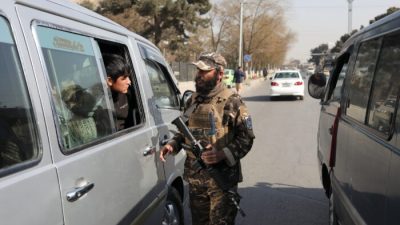Боец Талибана* обыскивает автомобиль во время охраны контрольно-пропускного пункта в Кабуле, Афганистан, 27 ноября 2021 года. (AliKhara/Reuters)
