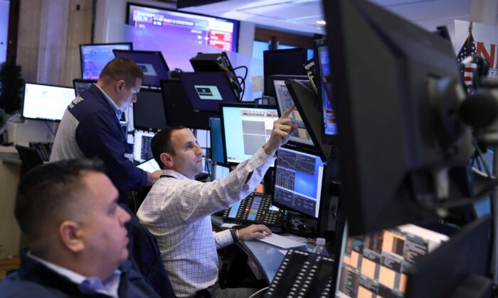 Трейдеры в торговом зале Нью-Йоркской фондовой биржи (NYSE) в Нью-Йорке, 7 марта 2022 года.(AndrewKelly/Reuters)
