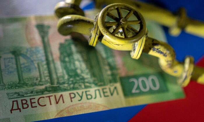 Покупатели российского газа сбиты с толку требованием Путина об оплате в рублях Модель газопровода на российской банкноте и флаге, сделанной 23 марта 2022 года. Фото: REUTERS/DadoRuvic/Illustration